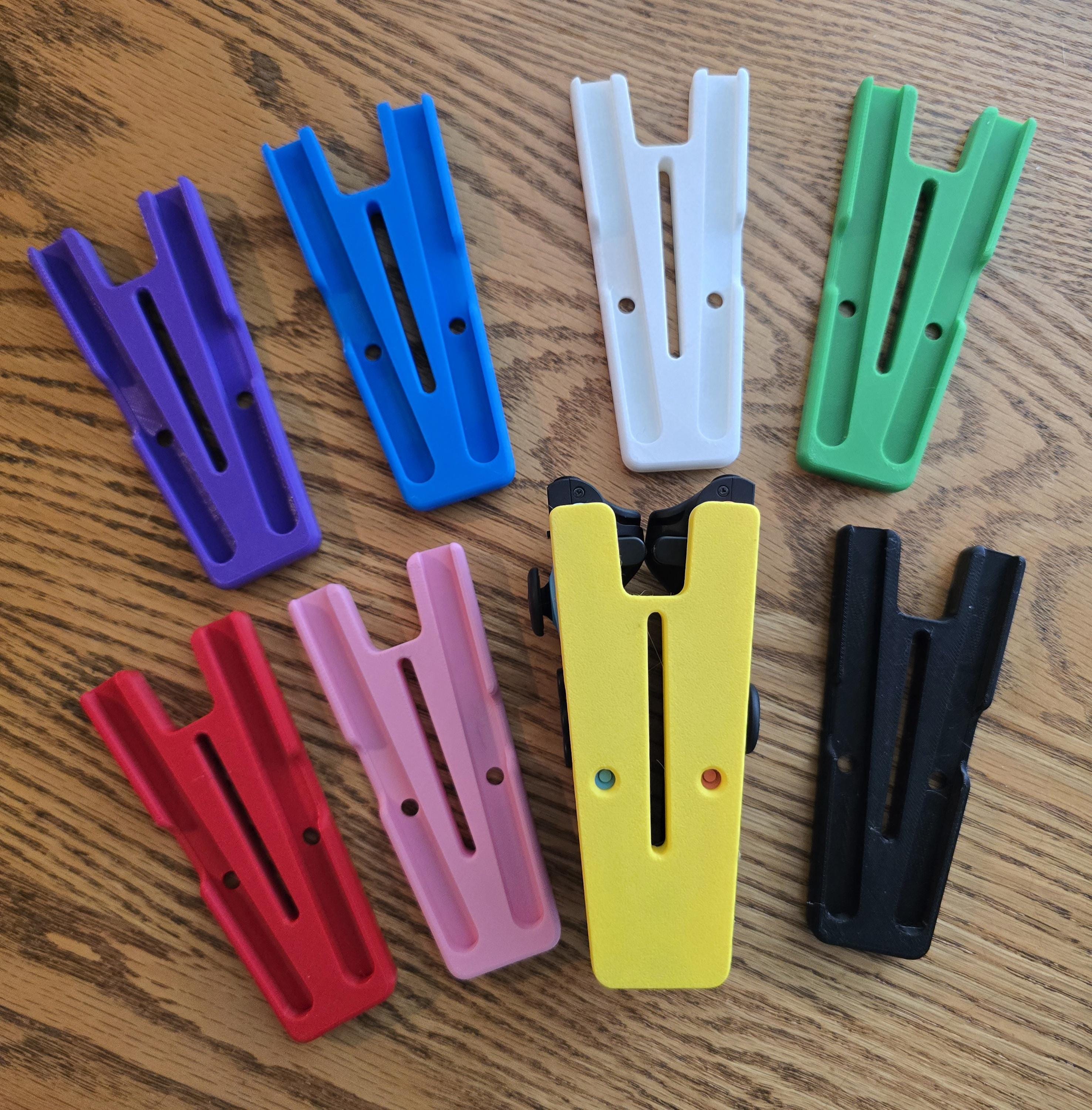 a variety of colorful plastic parts, including purple, blue, white, green, pink, yellow, and black, arranged on a wooden surface.