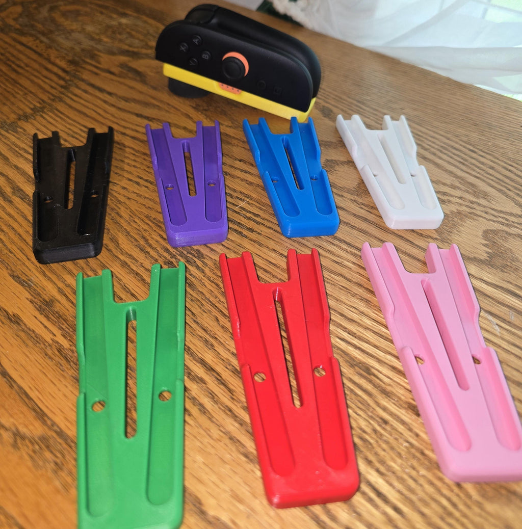 a collection of colorful plastic parts, including a stapler, on a wooden surface.