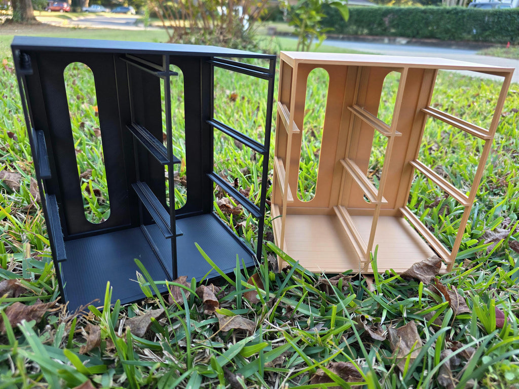 Two wooden crates, one black and one brown, are sitting on a grassy lawn.