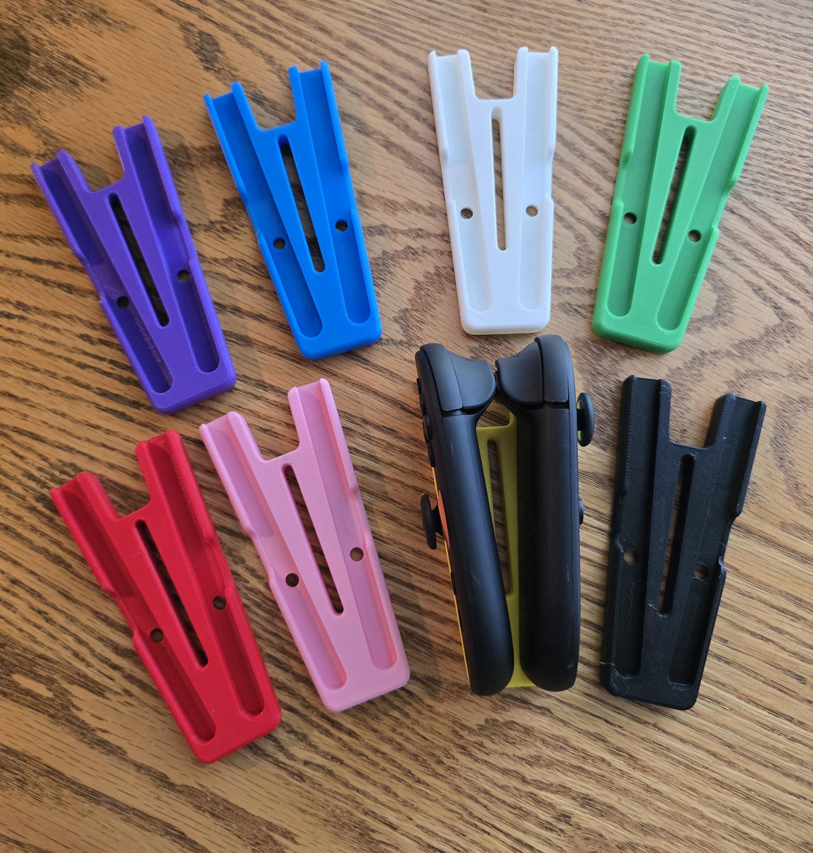 a collection of colorful plastic parts, including handles and connectors, arranged on a wooden surface.